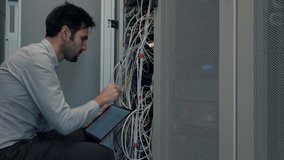 Male Man Server IT Engineer Work In Data Center. Technical Engineer Working With Wires To Resolve Problem. Server Cabinets On Server Room. Programmer Checks Data Center Neural Network Mainframe Host - Powered by Shutterstock - Get 15% off with code: PIKWIZARD15