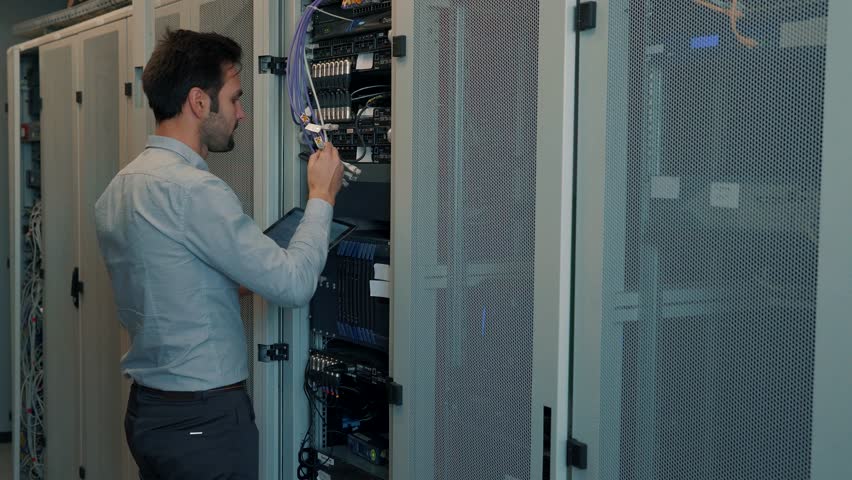 Data Center. Server Room. IT Engineer Work In Data Center Server. Technical Engineer Working With Wires Resolve Problem. Server Cabinets In Server Room. Programmer Checks Work Of Network Equipment Royalty-Free Stock Footage #1025321606