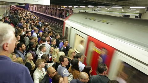 LONDON - CIRCA SEPTEMBER 2014, Busy London underground subway train station time-lapse. Platform and stairs packed with people train arrives, doors open and the crowds move to board train, doors close