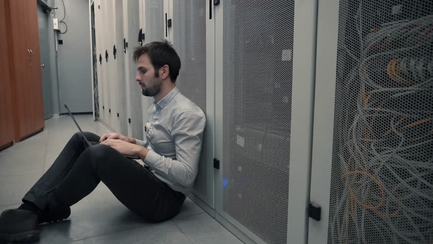 Network Engineer Working In Server Room. It Specialist On Computer Console PC.IT Technician Works With Ware And Cables in Big Data Center. Network Engineer Resolving Problem In Server Room Backup Data Royalty-Free Stock Footage #1025323313
