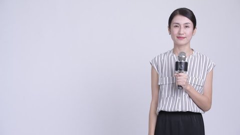 Happy beautiful Asian businesswoman as newscaster presenting something
