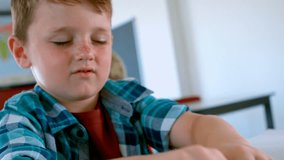 Front view close up of blind Caucasian schoolboy reading a braille book at desk in classroom at school. He is closed his eyes 4k - Powered by Shutterstock - Get 15% off with code: PIKWIZARD15