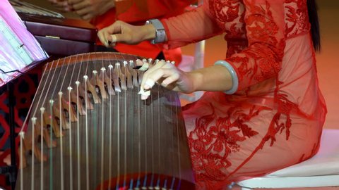 Chinese traditional musician playing chinese guzheng,