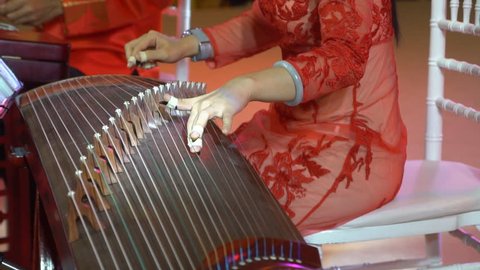 Chinese traditional musician playing chinese guzheng,