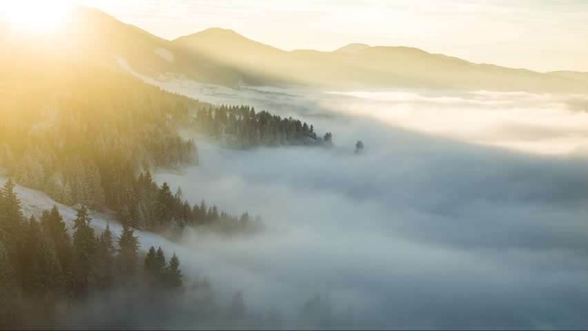 Timelapse over the frozen forest during sunset cloud inversion.