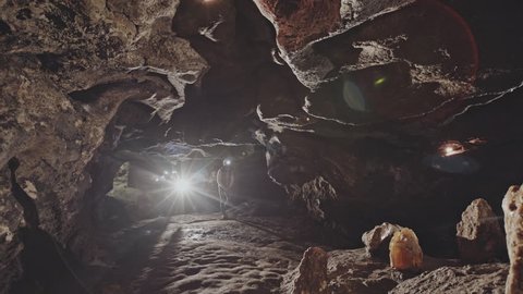 People examining stones in cave