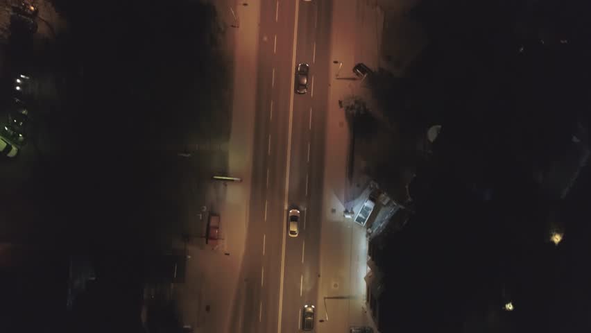 Aerial footage following a car in urban area at night