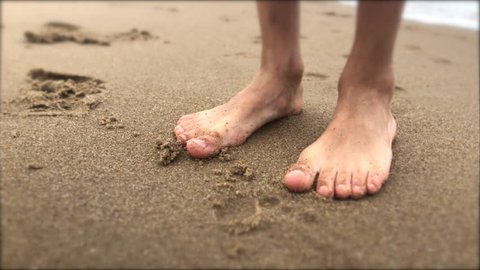 Child feet walking at the beach