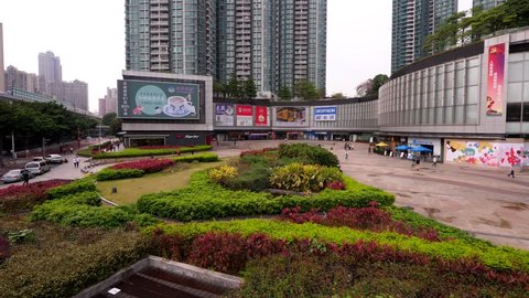 GUANGZHOU, CHINA - MARCH 15, 2018: Green lawn island at urban square, modern residential and shopping complex, Metropolitan Plaza at Liwan District of Guangzhou. Wide angle panning shot