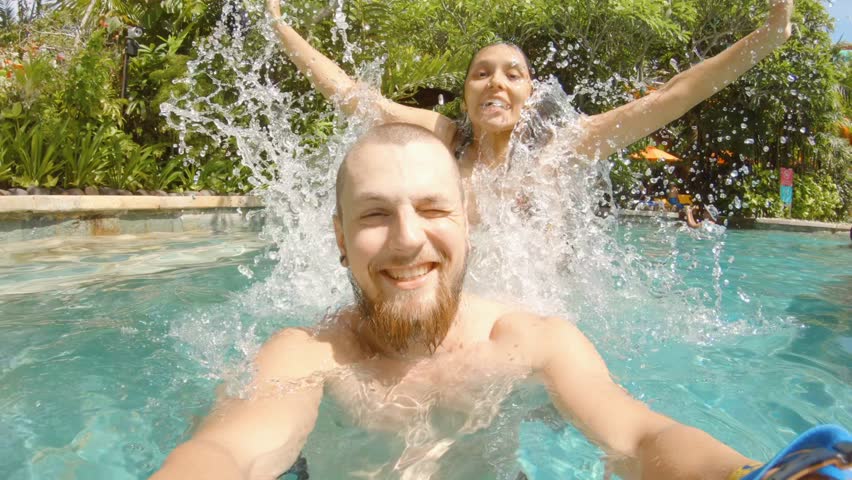 Smiling Young Couple Doing Piggyback Ride in Swimming Pool. Honeymoon Funny Selfie with GoPro Camera 4K Slow Motion Footage. Bali, Indonesia. | Shutterstock HD Video #1025359568