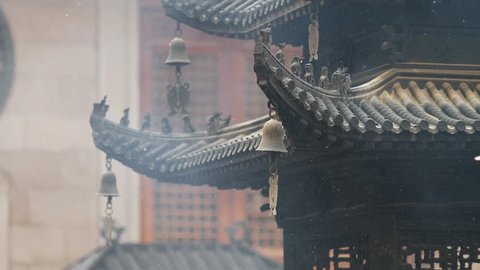 Immortal and beasts on the eaves of the building in Shanghai Jingan temple, Imperial yellow roof decorations, Wind bells under eaves sway with the wind, 4K video, slow motion. 