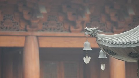 Immortal and beasts on the eaves of the building in Shanghai Jingan temple, Imperial yellow roof decorations, Wind bells under eaves sway with the wind, 4K video, slow motion. 