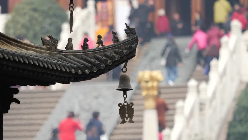 Immortal and beasts on the eaves of the building in Shanghai Jingan temple, Imperial yellow roof decorations, Wind bells under eaves sway with the wind, 4K video, slow motion. 