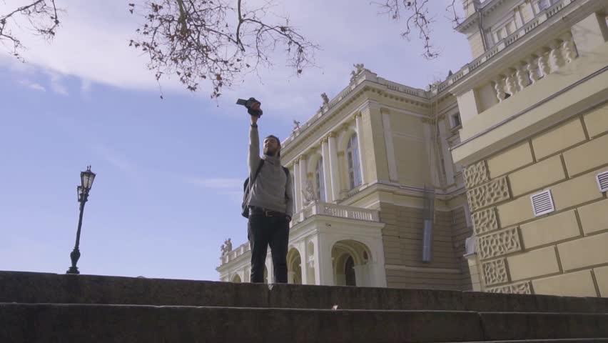 Young male traveler bloger filming outdoors video with digital camera 