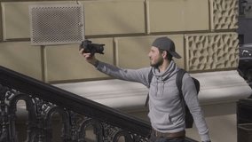 Young male traveler bloger filming outdoors video with digital camera 