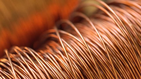 Close up of the bare bright copper wire on the spool, Rack focus
