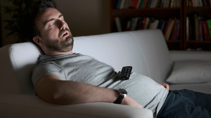 Video is about one lazy man asleep watching television at night alone | Shutterstock HD Video #1025366870