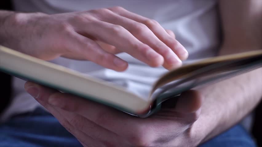 Hand and book: reading a book and holding your fingers along the lines. A man's hand holds a book and moves his fingers along the page while reading. The reader of the book holds Royalty-Free Stock Footage #1025367872