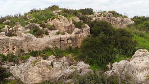 Two ancient Semitic (Phoenician) letters "ein" and "tav" carved in the rock. "AT" - the unfinished word "ATLIT" in the modern city of Atlit on the northern coast of Israel.
