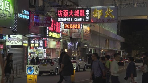 Crowd of people on the street in Tsim Sha Tsui district. Hong Kong at night. Many chinese signs on busy street - October 2018: Hong Kong, China