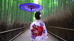 Asian woman wearing japanese traditional kimono at Bamboo Forest in Kyoto, Japan. 4K