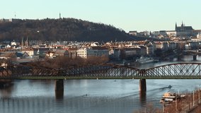 Prague - Elevated city view with train 
 on railway bridge, river and Prague Castle in background. 4K resolution
