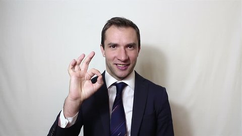 Young handsome businessman says ok and shows gesture ok.Portrait on a white background.