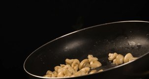 Cooking champignons mushrooms tossing in Pan Slow motion 4K video