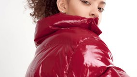 young woman with red lacquer lips and red shiny jacket on white in studio turning to the camera - Powered by Shutterstock - Get 15% off with code: PIKWIZARD15