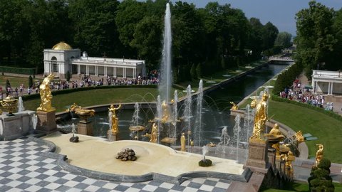 Saint Petersburg, Russia, March 2019: Long shot of crowd of people visiting the gardens of Peterhof palace with golden fountains