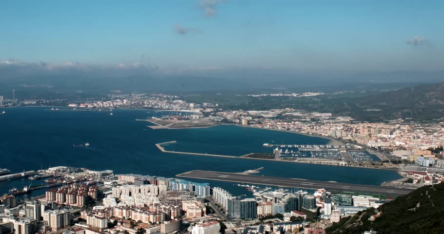 Aerial panoramic view of top of Gibraltar Rock, in Upper Rock Natural Reserve and plane takeoff from Gibraltar International Airport. United Kingdom, Europe