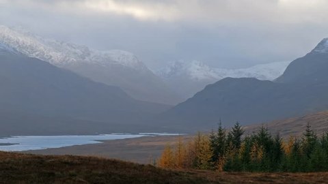 Snow is falling in the highlands of scotland.