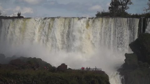 Iguazu Falls / Argentina - May 2015: Tourists in front of the powerful Iguazu Falls waterfall at the border between Brazil and Argentina.