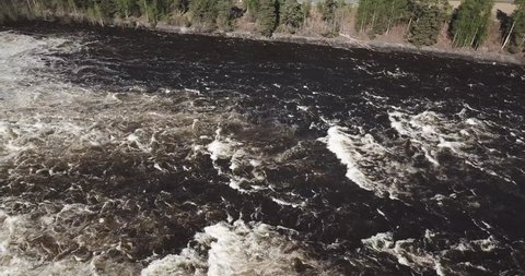 Drone shot of waterfall by a power plant in the summer sun. The flood is at the highest in the river. No colorgrading or editing done to the video.
