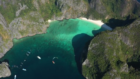 View from above, stunning aerial view of Koh Phi Phi Leh (Phi Phi Island) with the beautiful Maya Bay. A turquoise and clear water bathes a white beach surrounded by limestone mountain. Thailand.