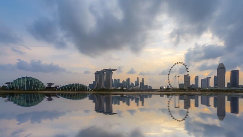Beautiful Time lapse of Day to Night of Marina Bay Sands area CBD in Singapore city skyline by a river at dusk with reflection. Pan down motion timelapse. Royalty-Free Stock Footage #1025456555