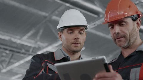 Engineer Plan of Manufacture Work. Male People in Hardhat or Safety Wear. Communication Process of Handsome Inspection Contractor with Machine Tool. Technical Profession of Mechanic Closeup Indoors