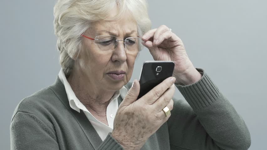 Senior woman with glasses using a smartphone, she has vision problems and can't focus and read on the digital display Royalty-Free Stock Footage #1025461223