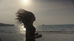 Young runner on the beach at sunset, slow motion clip