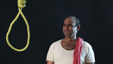 A sad Indian man standing in front of a noose in despair and stress