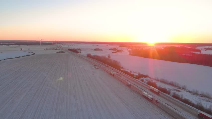 Sunset over fields and highway in winter time Sweden.