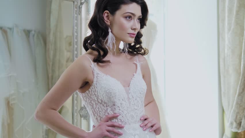 Beautifu bride choosing wedding dress in a wedding salon