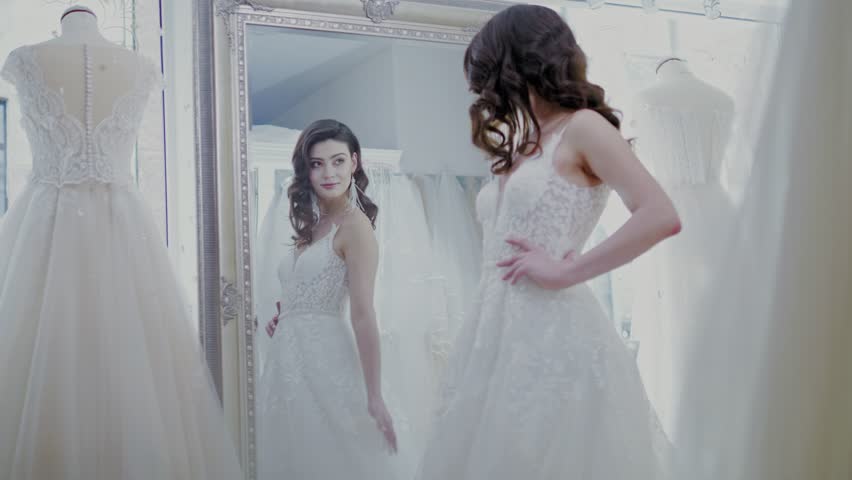Beautifu bride choosing wedding dress in a wedding salon