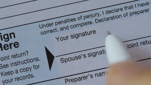 An Elderly Man Signs Irs Us Individual Income Tax Form 1040. Fake signature