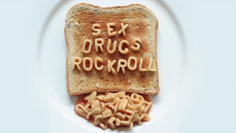 A slice of toast with alphabet spaghetti words sex, drugs and rock roll