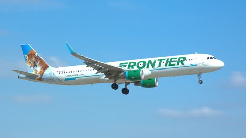 MIAMI, FL - 2019: Frontier Airlines Airbus A321 Commercial Jet Airliner featuring Cali the Mountain Lion Landing at MIA Miami International Airport on a Sunny Day in South Florida