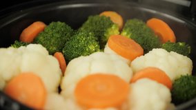 Cooking healthy steamed vegetables in multicooker, steamer. Medcine diet concept. The recipe video is a step by step of making vegetable soup