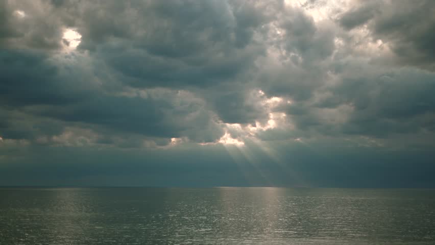 Beautiful rays of sun breaking through the clouds over the water sea or big lake