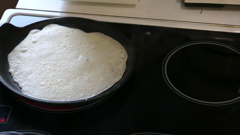 Baking Pancakes On A Frying Pan On Kitchen Stove. Slider Shot