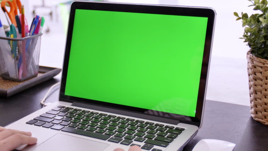 Over the shoulder shot of Asian boy looking at green screen. Office person using laptop computer with laptop green screen, 4K dolly shot right to left. Royalty-Free Stock Footage #1025509091